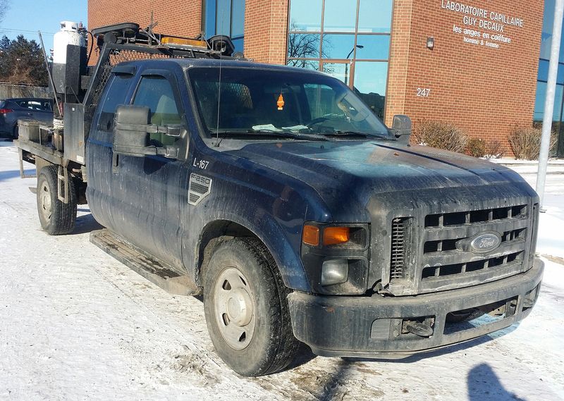Dark 2008-2010 Ford F-250 Super Duty work truck in snow