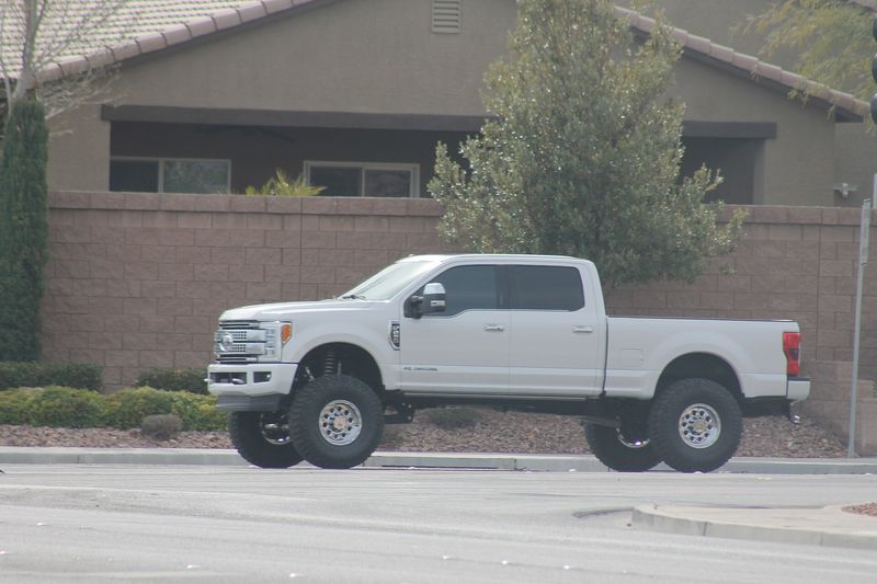 Lifted white Ford F-250 Super Duty on large tires